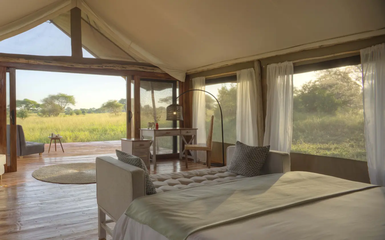 Luxury safari tent interior with bed overlooking savanna grassland, Tarangire Ndovu Tented Lodge, Tarangire National Park, Tanzania