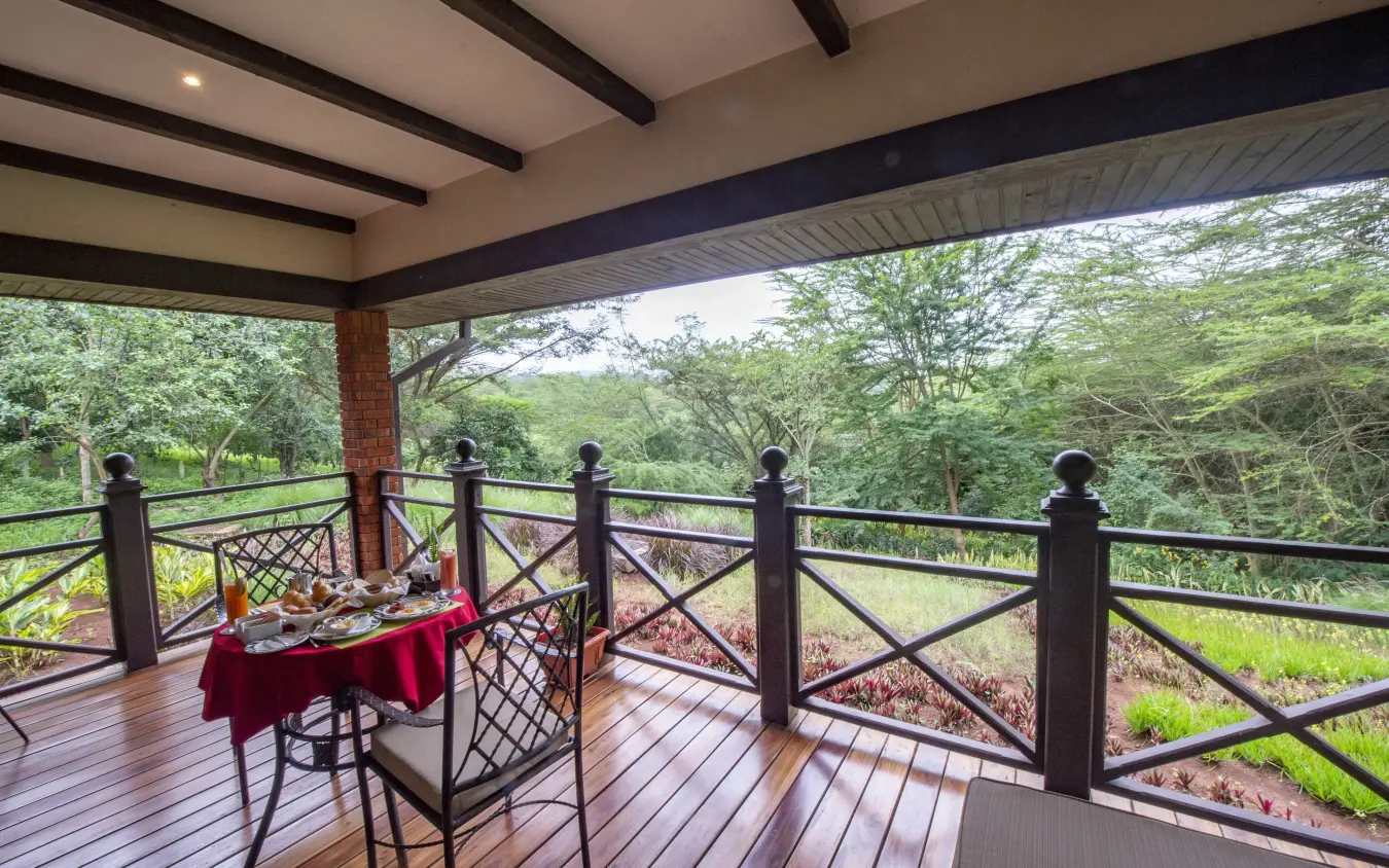Covered deck with dining table overlooking forested valley landscape, The Retreat at Ngorongoro, Ngorongoro Crater, Tanzania