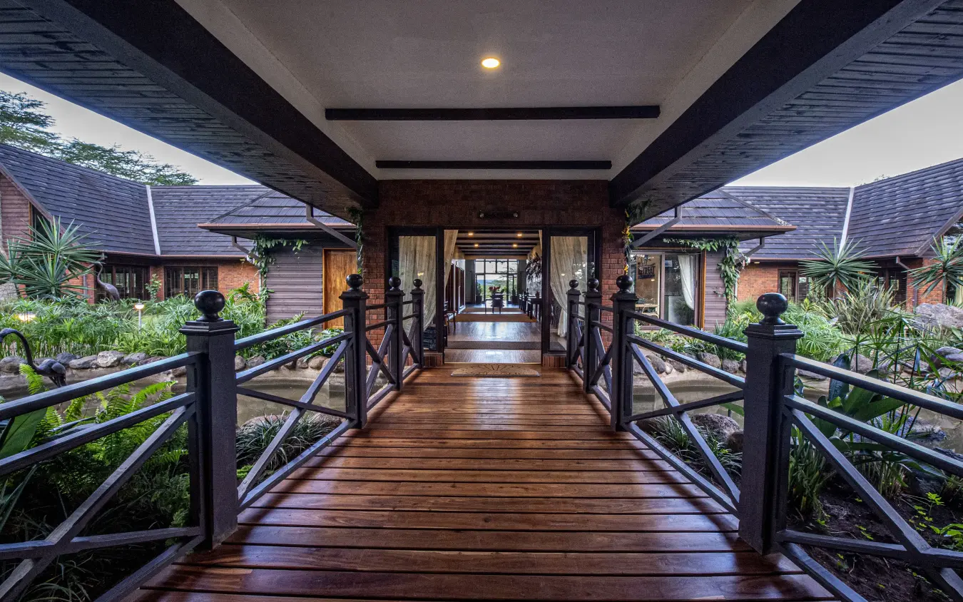 Covered wooden boardwalk connecting luxury bungalows with tropical gardens, The Retreat at Ngorongoro, Ngorongoro Crater, Tanzania
