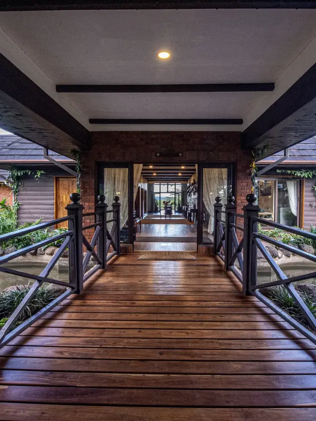 Covered wooden boardwalk connecting luxury bungalows with tropical gardens, The Retreat at Ngorongoro, Ngorongoro Crater, Tanzania