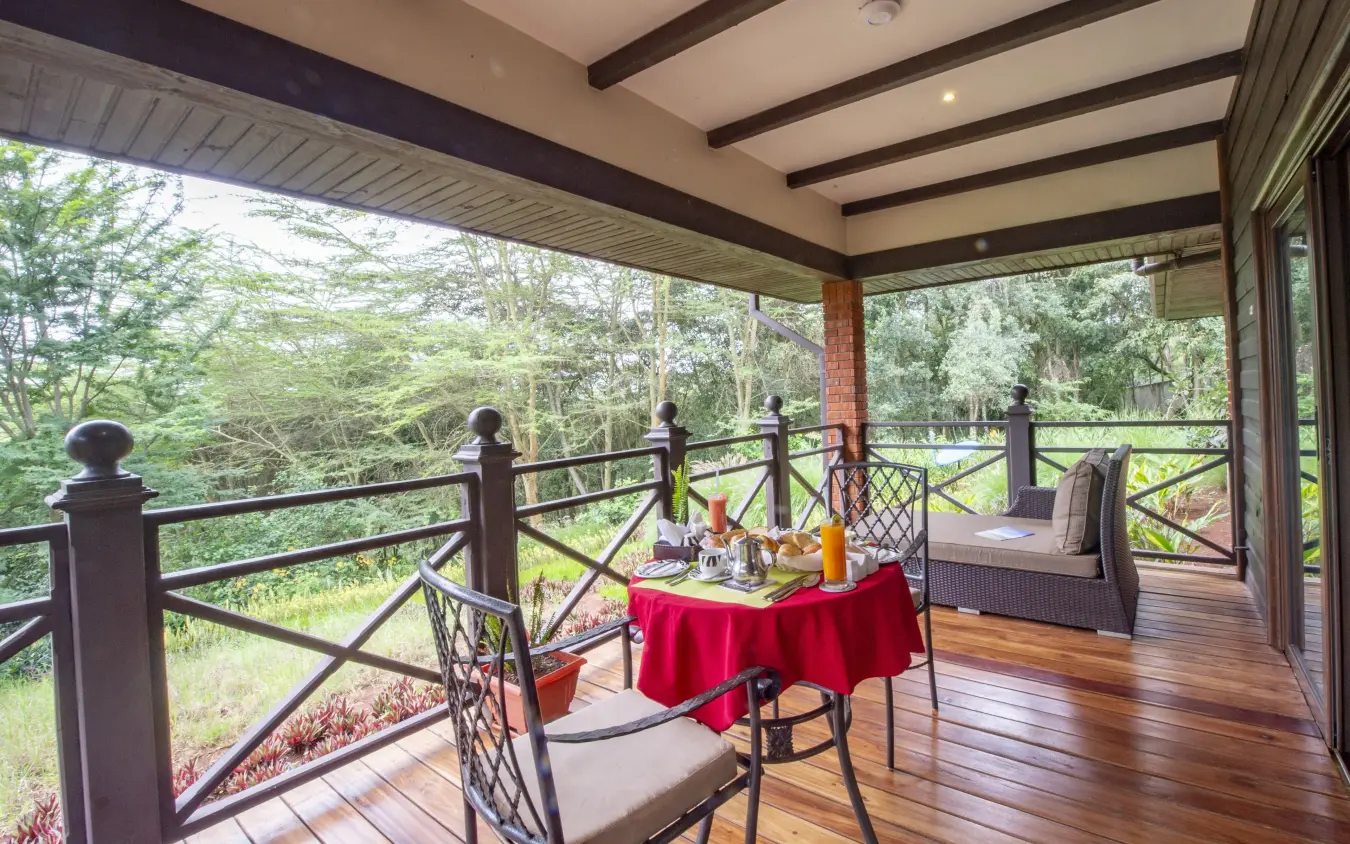 Covered deck with dining table overlooking forested valley, The Retreat at Ngorongoro, Ngorongoro Crater, Tanzania