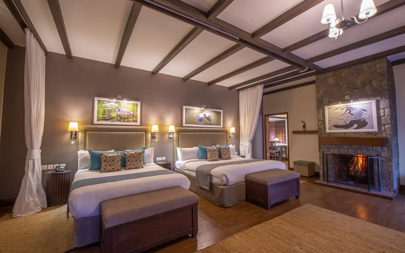 Luxury bedroom suite with fireplace and dual beds, The Retreat at Ngorongoro, Ngorongoro Crater, Tanzania