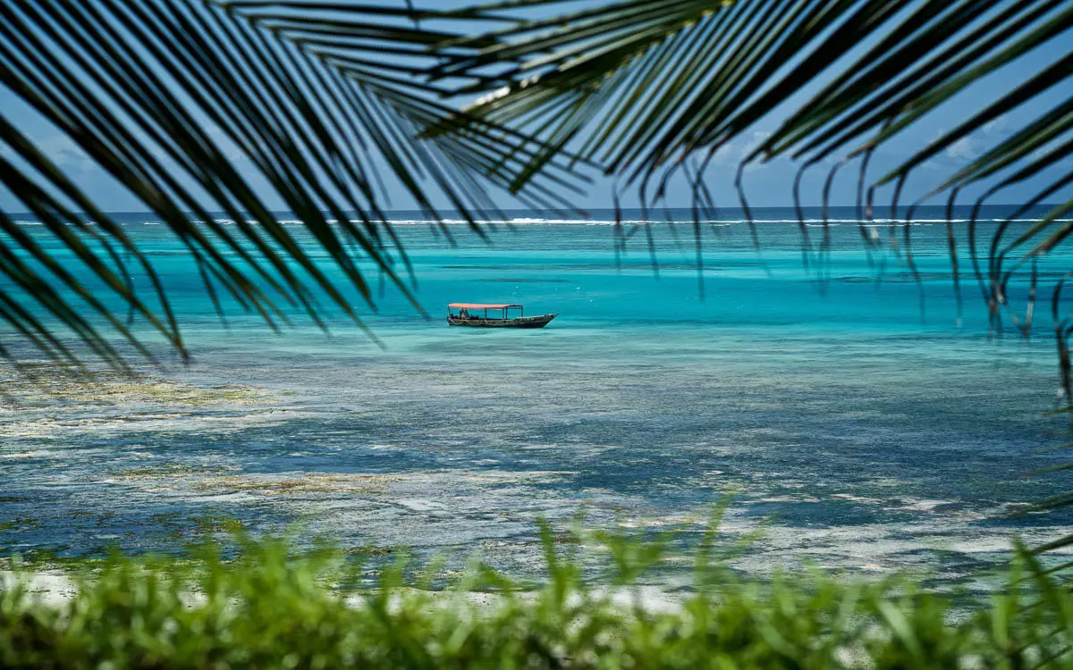 Turquoise ocean view with traditional boat anchored offshore, Zawadi Hotel, Zanzibar & Pemba, Tanzania
