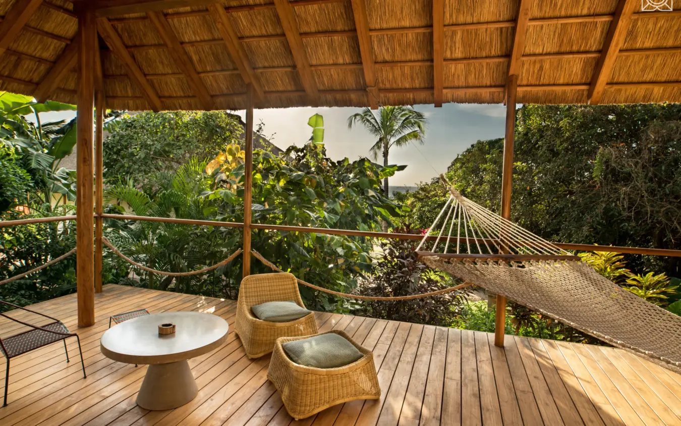 Wooden deck with wicker chairs and hammock overlooking tropical forest, Zuri Zanzibar, Zanzibar & Pemba, Tanzania