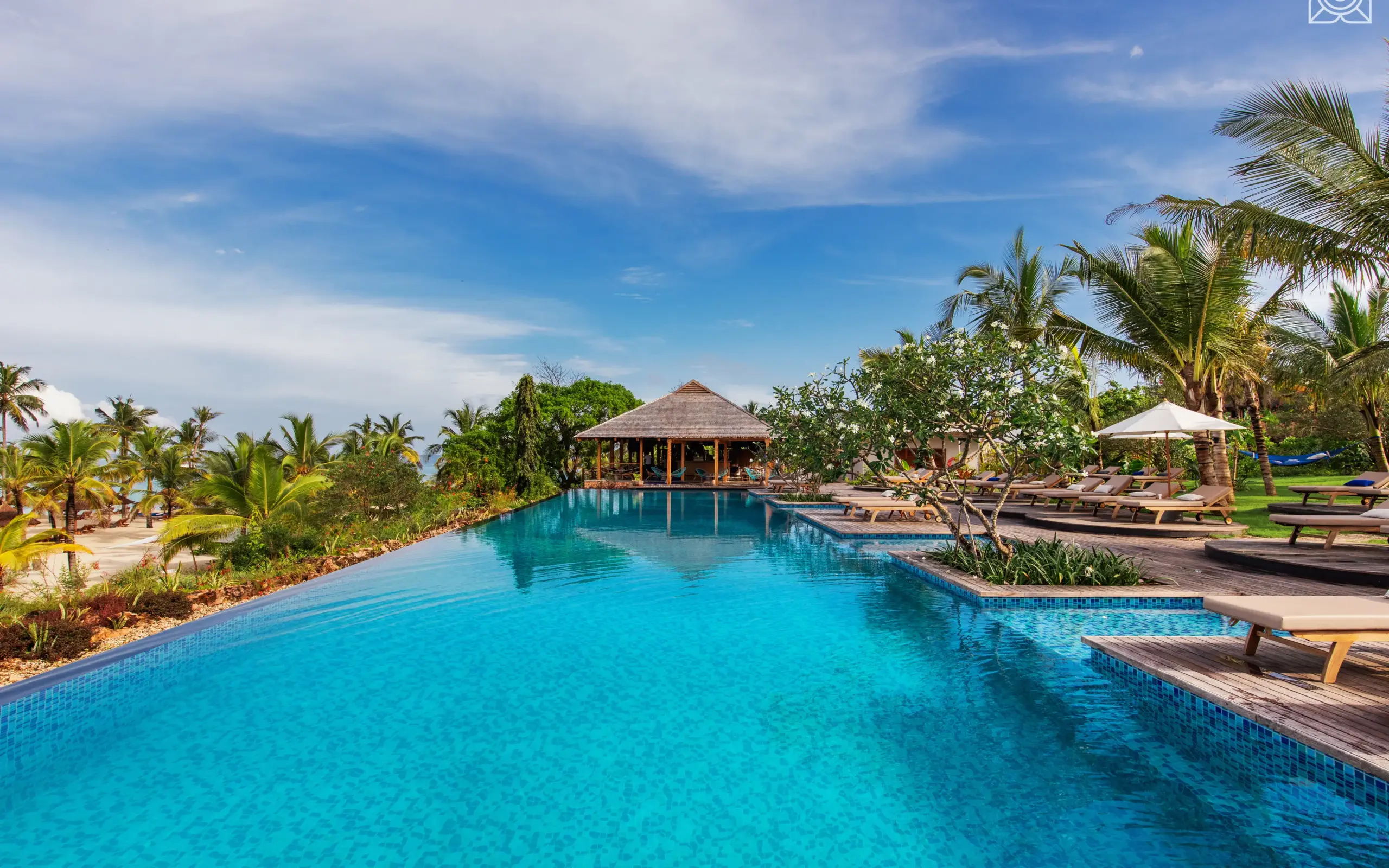 Long resort pool with thatched structures and palm trees, Zuri Zanzibar, Zanzibar & Pemba, Tanzania