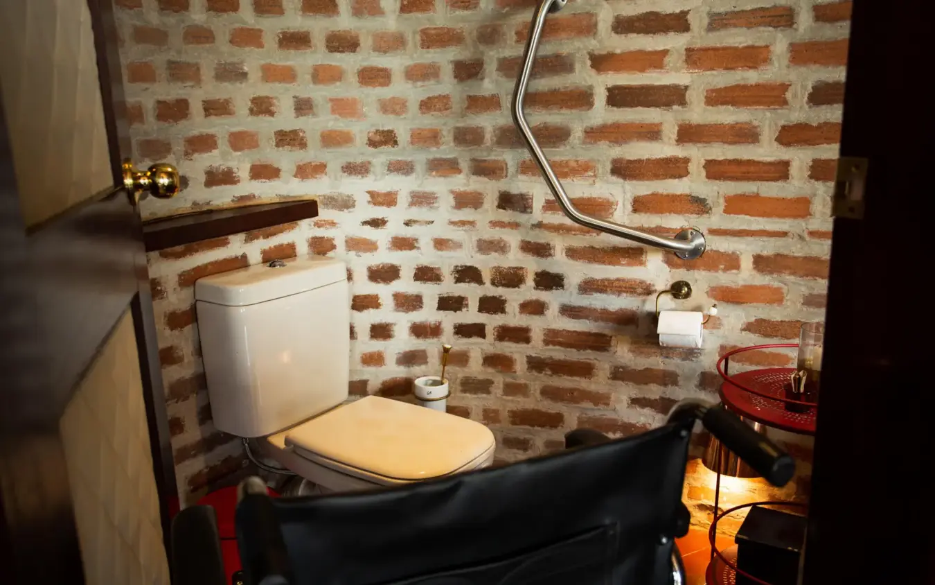 Bathroom with exposed brick walls and white toilet, Angama Mara, Maasai Mara, Kenya