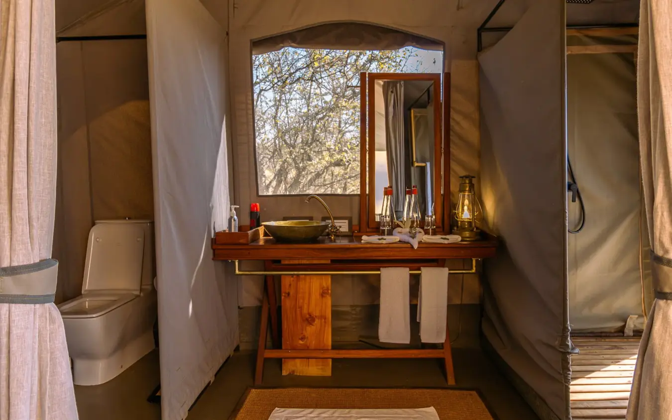 Luxury safari tent bathroom with wooden vanity and savanna views, Basecamp Wilderness, Maasai Mara, Kenya