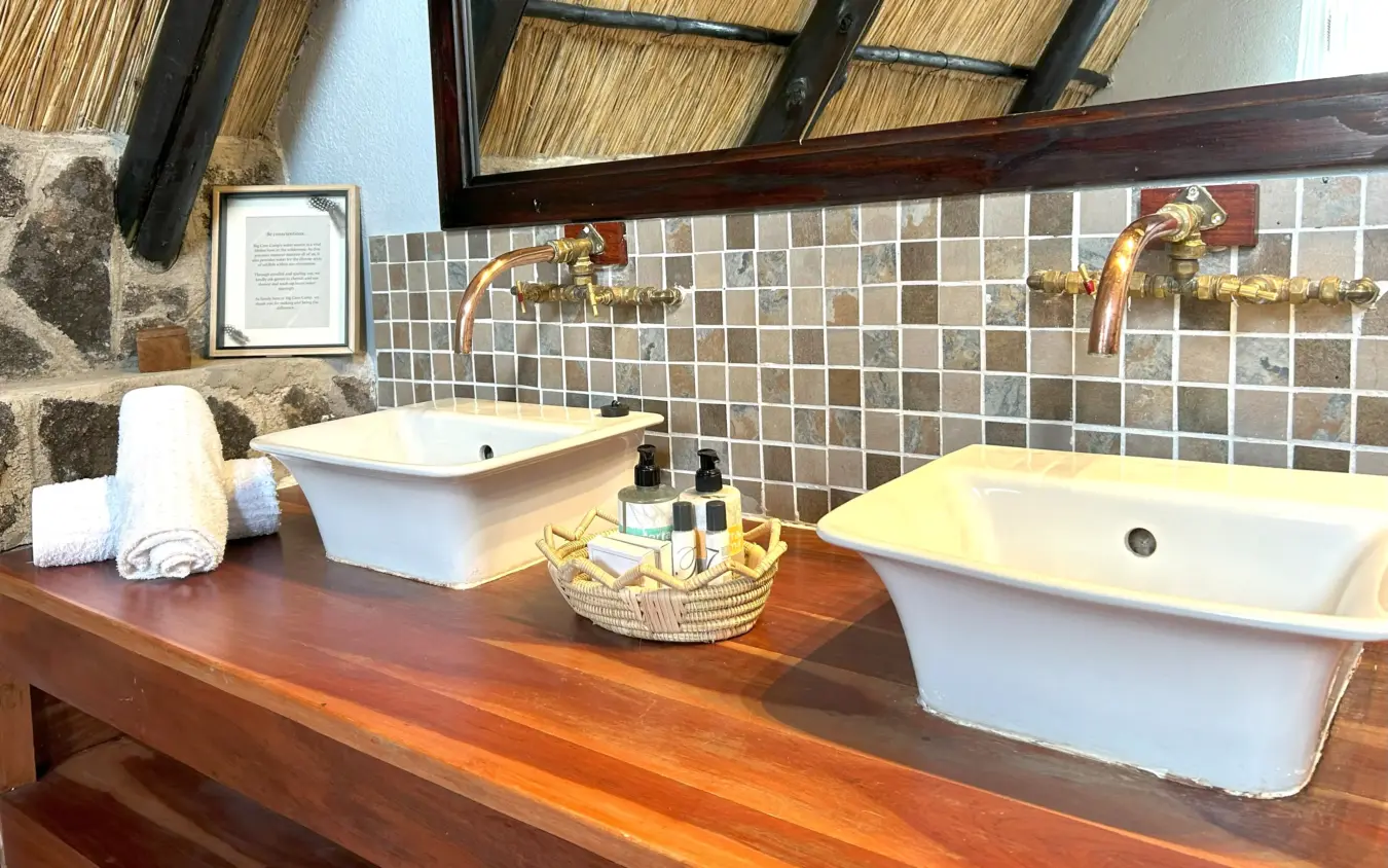 Luxury bathroom with dual vessel sinks and thatched ceiling details, Big Cave Camp, Matobo, Zimbabwe