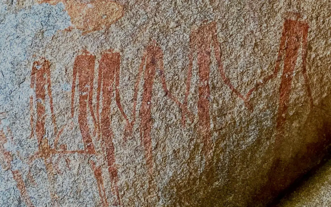Ancient rock art with red ochre hand stencils on stone surface, Big Cave Camp, Matobo, Zimbabwe