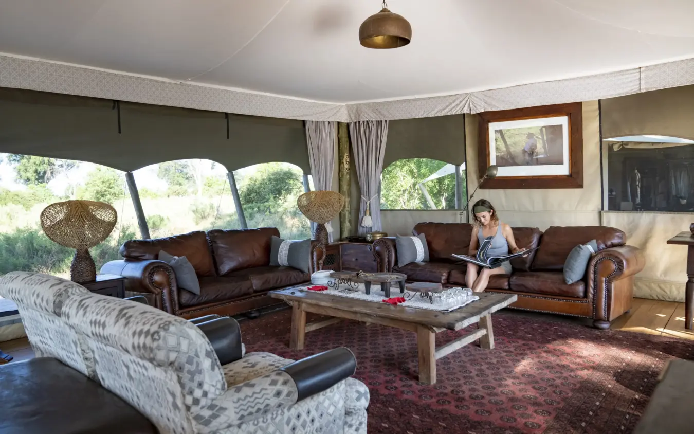 Luxury safari lodge interior with leather seating and expansive window views, Duba Explorers Camp, The Okavango Delta, Botswana
