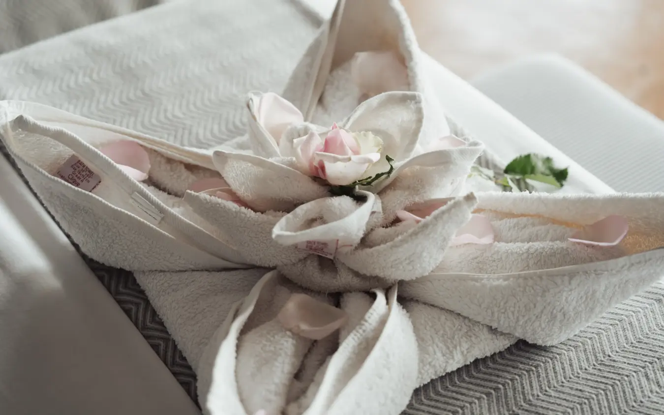 Napkin folded with small pink flower and ring on white place setting, The Emakoko, Nairobi, Kenya