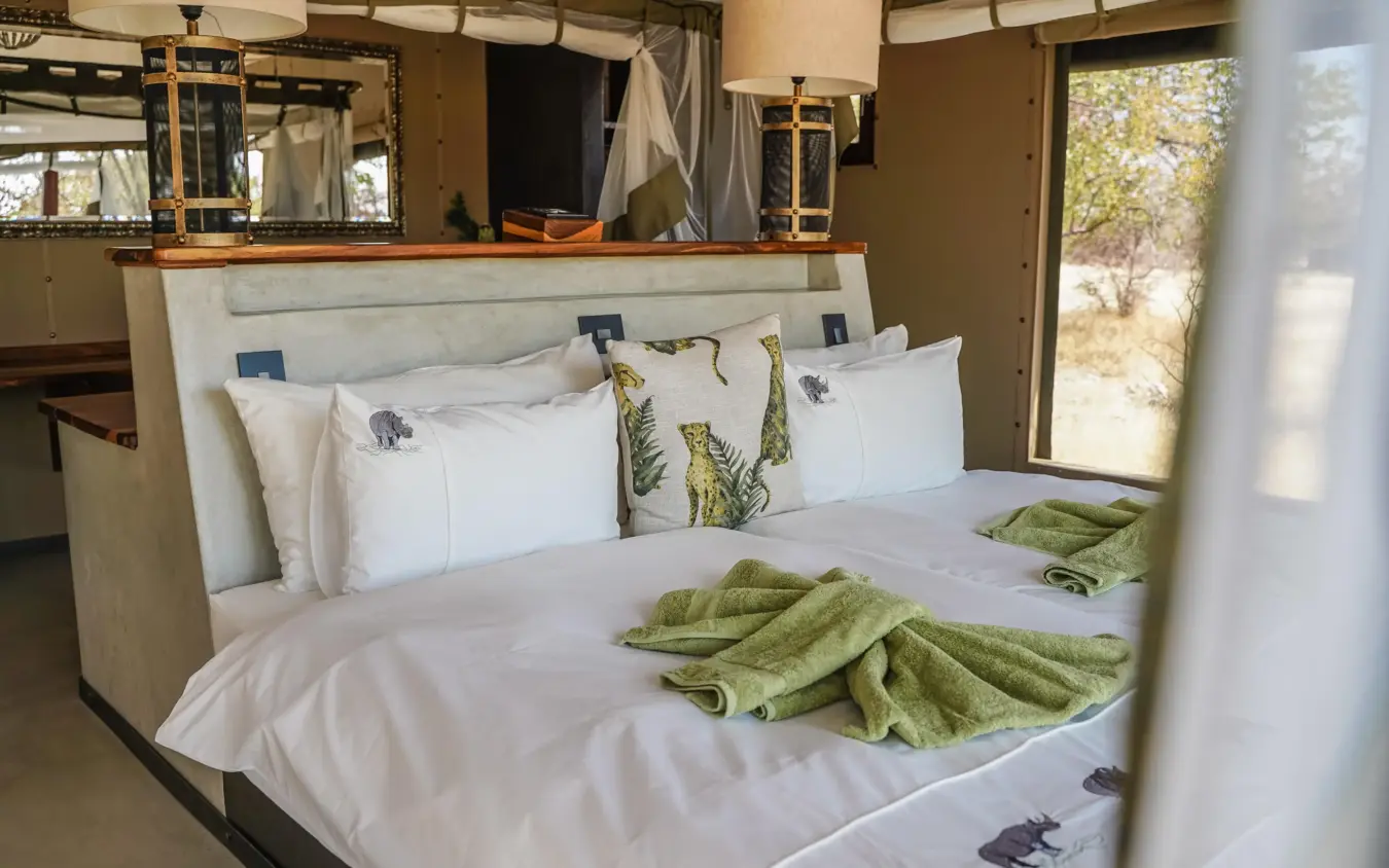 Bedroom with white bedding, green accents, safari lodge decor, Etosha Oberland Lodge, Etosha National Park, Namibia