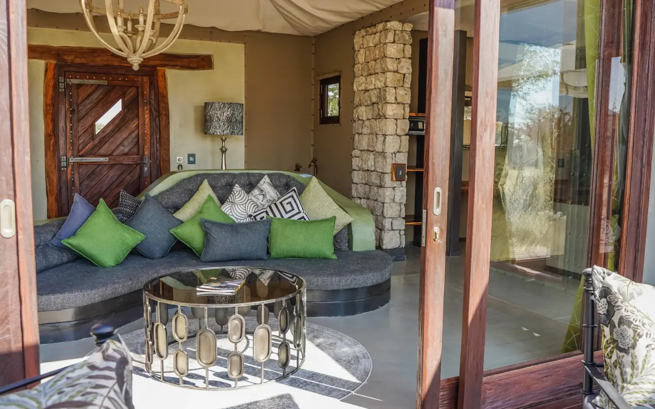 Modern lounge with curved seating and green accent pillows, Etosha Oberland Lodge, Etosha National Park, Namibia