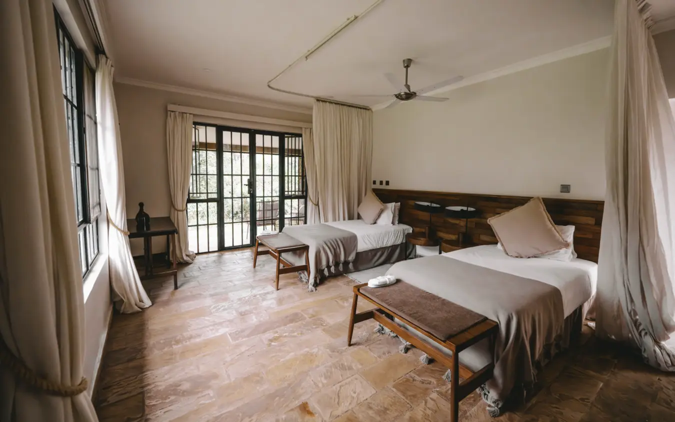 Spacious bedroom with twin beds and open doors to savanna views, Hamerkop House, Arusha, Tanzania