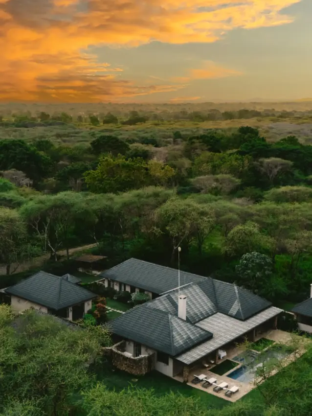 Modern safari lodge with dark roof overlooking vast bushland at sunset, Hamerkop House, Arusha, Tanzania