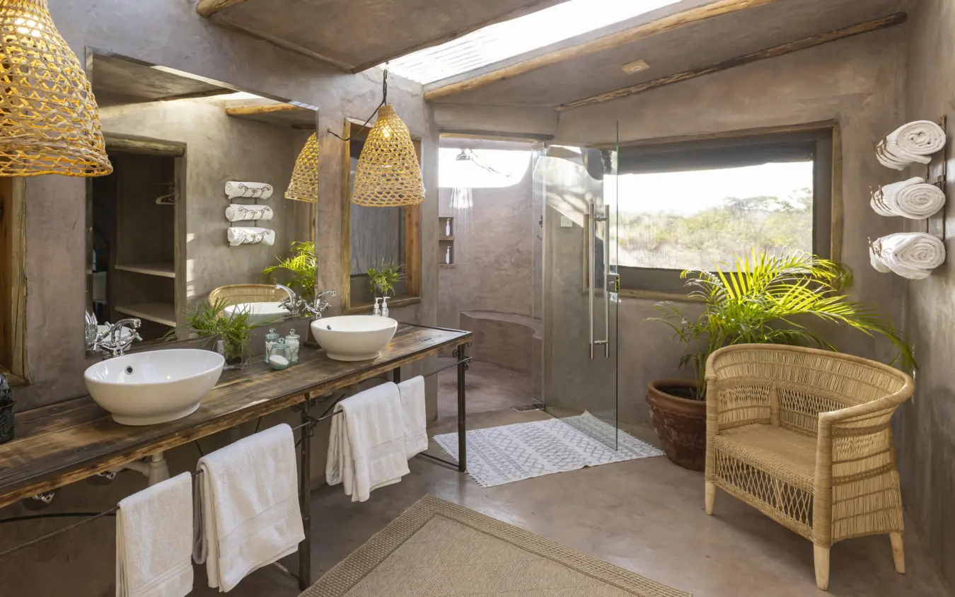 Luxury bathroom with dual vanities and shower overlooking natural landscape, Hemingways River Camp Mara, Maasai Mara, Kenya