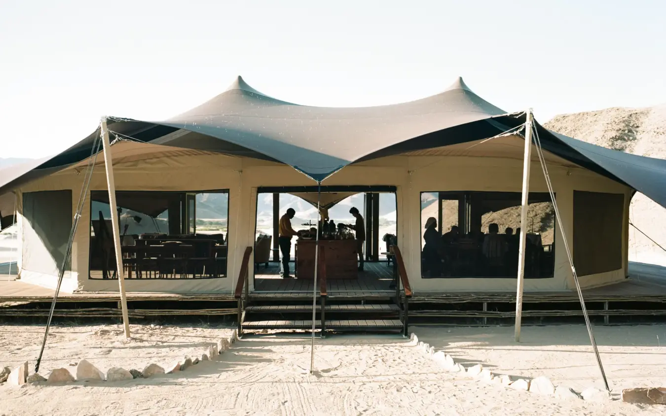 Canvas safari lodge with peaked roof on sandy beach, Hoanib Valley Camp, Damaraland, Namibia