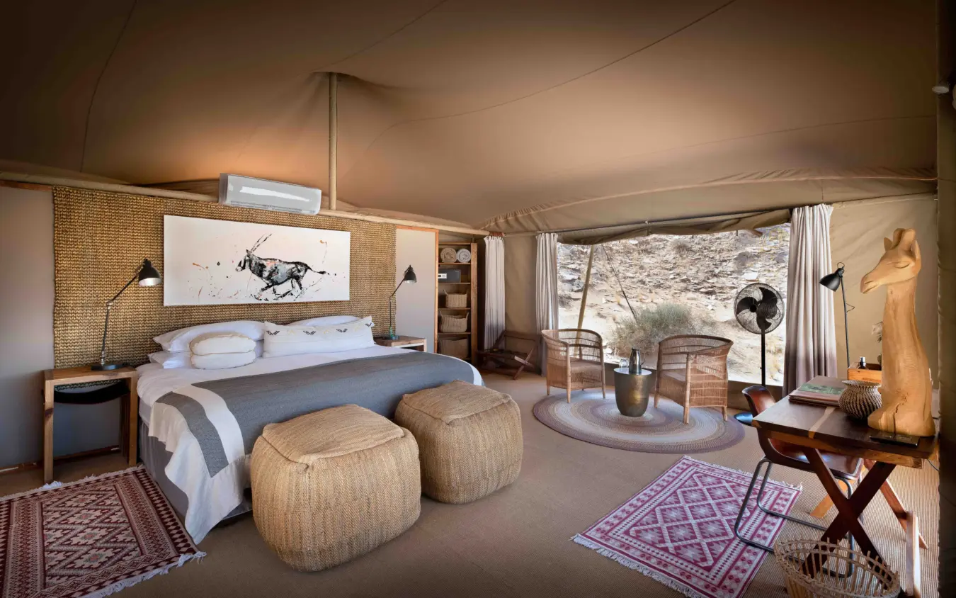 Luxury safari tent bedroom with canvas walls and savanna views, Hoanib Valley Camp, Damaraland, Namibia