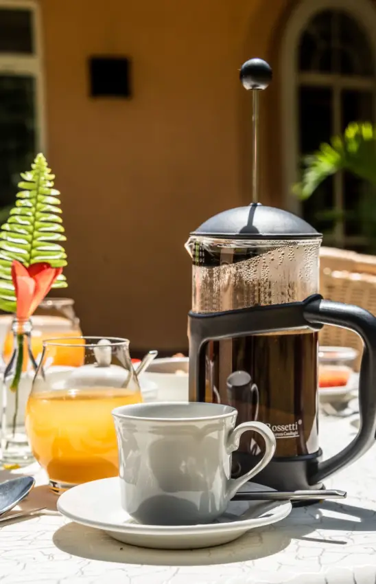 French press coffee service on courtyard table with terracotta architecture, House of Waine, Nairobi, Kenya