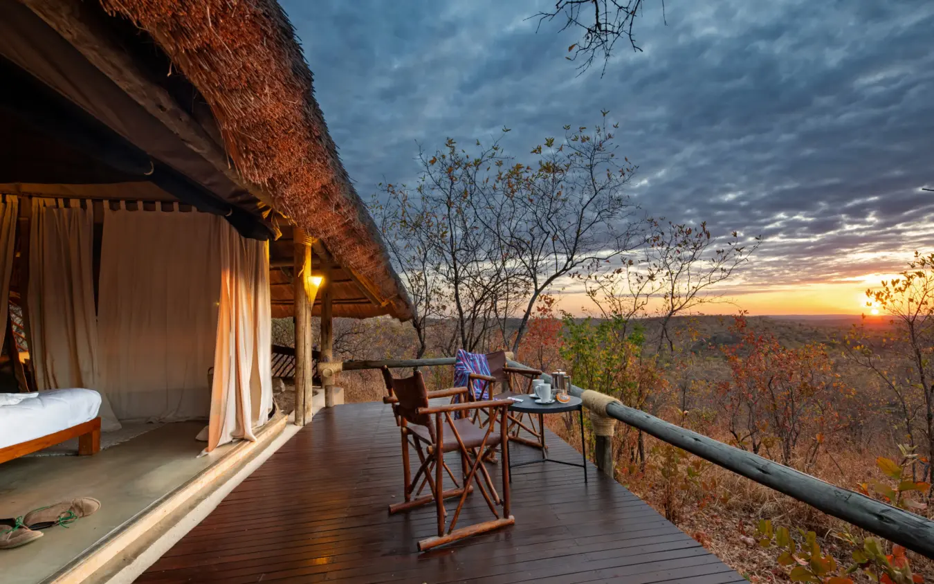 Luxury safari lodge deck with sunset view over bushland landscape, Ikuka Safari Camp, Ruaha National Park, Tanzania