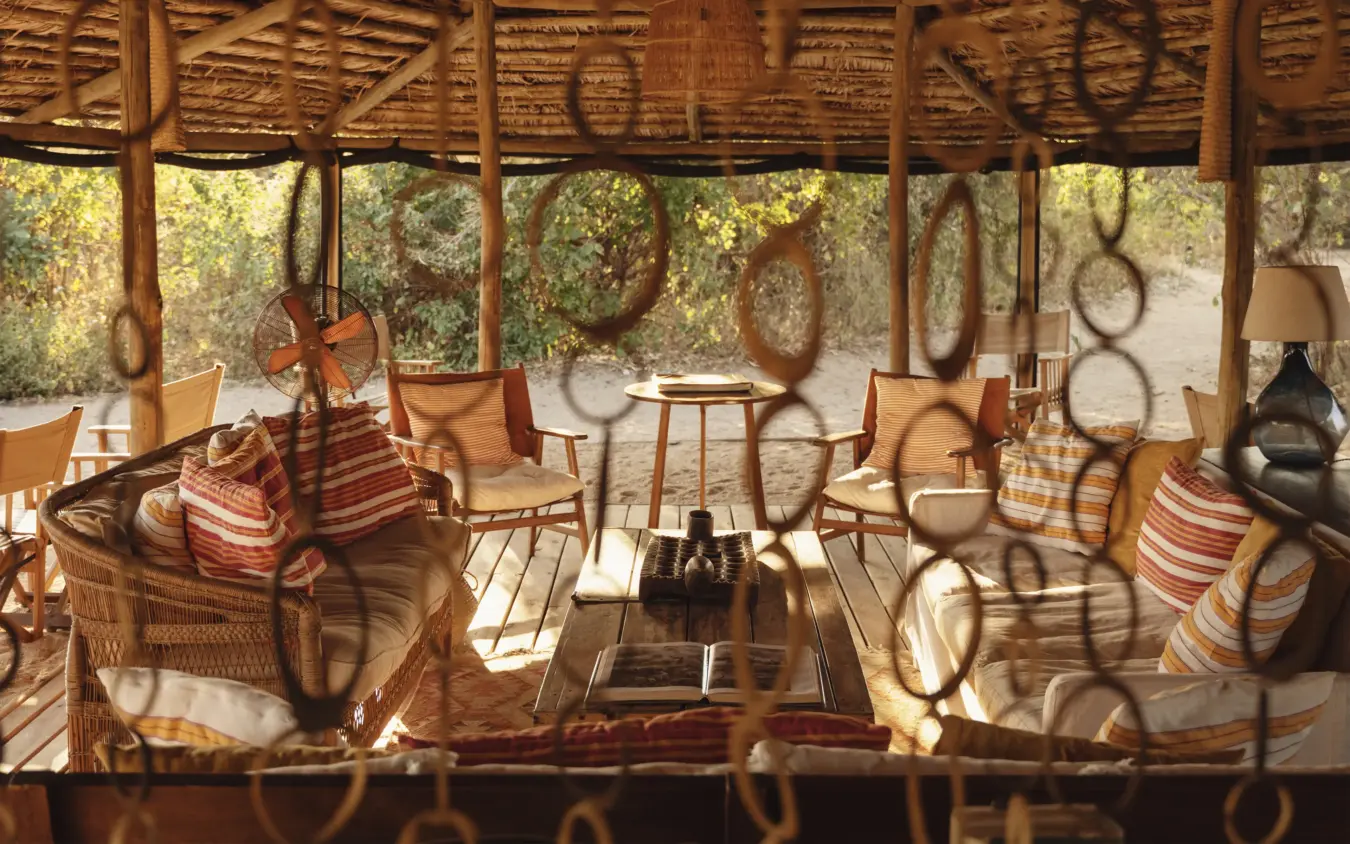 Shaded lounge area with woven furniture and savanna views through open sides, Kigelia Ruaha, Ruaha National Park, Tanzania