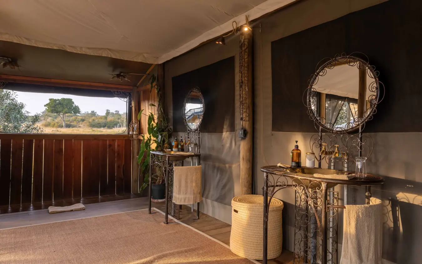 Luxury safari lodge pavilion with decorated vanity and savanna landscape views, Kimya Kimya Camp, Maasai Mara, Kenya