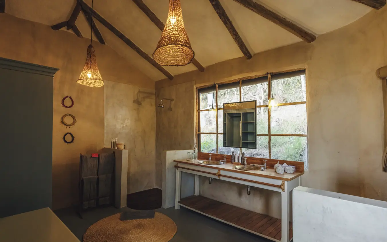 Luxury bathroom with double vanity and large windows overlooking natural landscape, Lamai Serengeti, Serengeti National Park, Tanzania