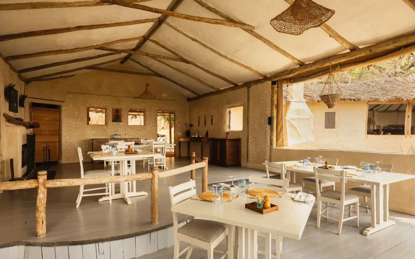 Open-sided dining pavilion with cream canvas roof and wooden furniture, Lamai Serengeti, Serengeti National Park, Tanzania