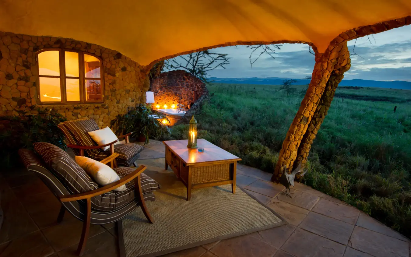 Luxury lodge terrace with chairs overlooking vast savanna landscape at dusk, Lewa House, Laikipia Highlands, Kenya
