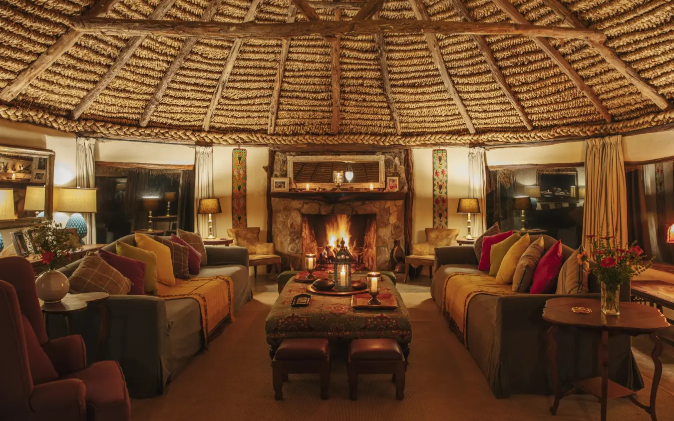Circular thatched-roof lounge with fireplace and safari-themed furnishings, Lewa House, Laikipia Highlands, Kenya