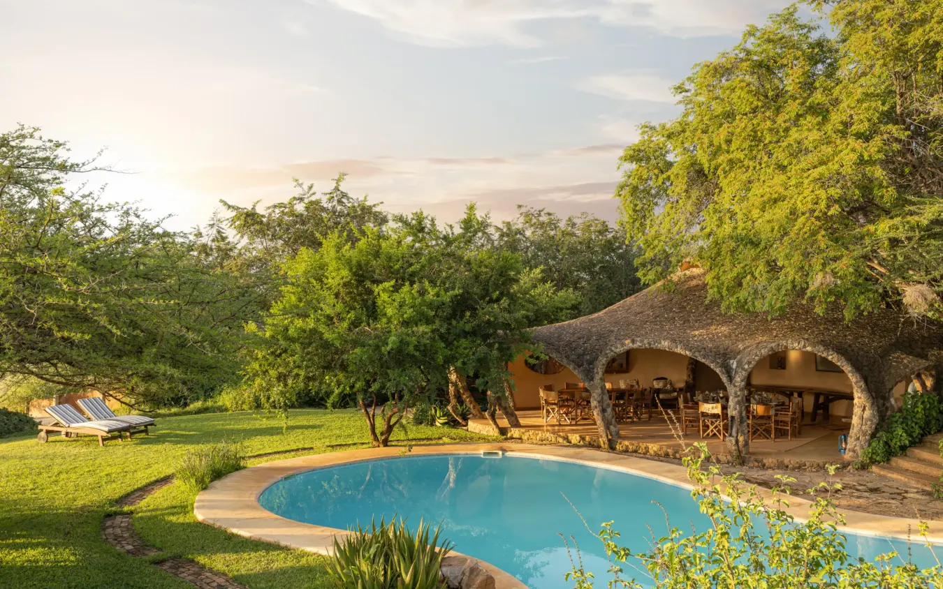 Luxury stone lodge with curved archways overlooking circular pool in woodland setting, Lewa House, Laikipia Highlands, Kenya