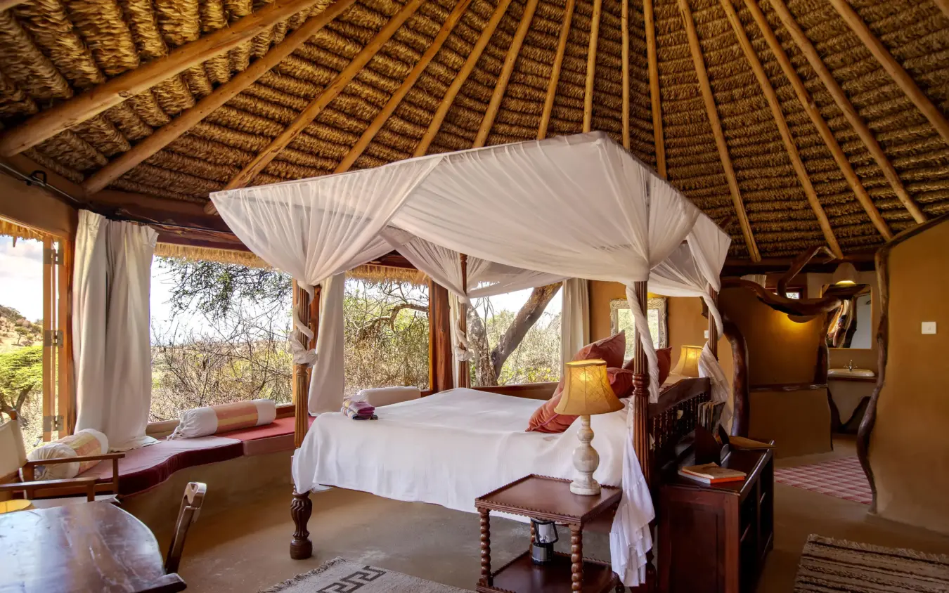 Spacious bedroom with four-poster bed and thatch ceiling, Lewa Wilderness, Laikipia Highlands, Kenya