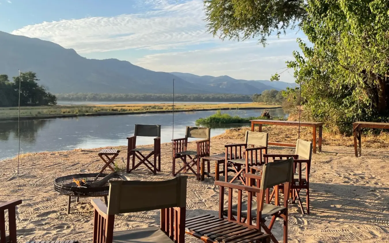 Riverside camp seating area with mountain backdrop and river, Little Vundu, Mana Pools, Zimbabwe