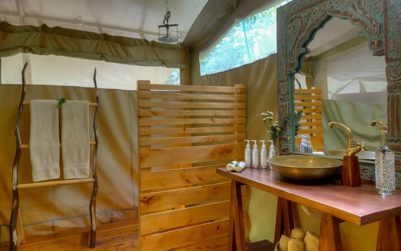 Luxury tent bathroom with wooden vanity and brass sink basin, Naibor Camp, Maasai Mara, Kenya