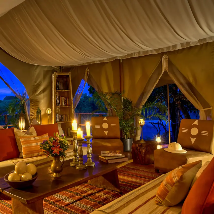Luxury safari tent interior with lounge area overlooking twilight landscape, Naibor Camp, Maasai Mara, Kenya