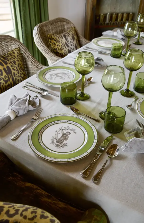 Formal dining table set with green-rimmed plates and wildlife motifs, Mama Simba, Arusha, Tanzania