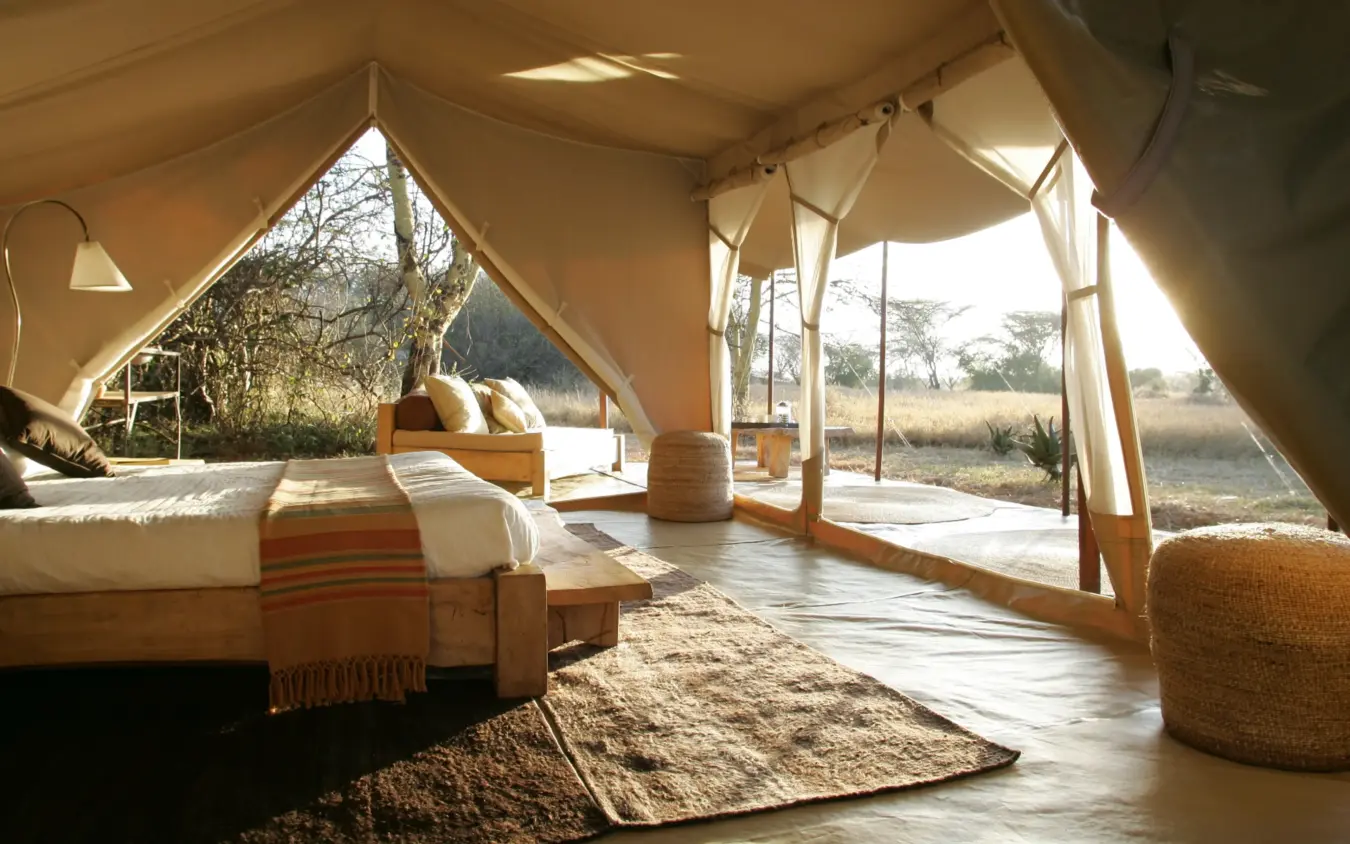 Interior of canvas safari tent with bed and seating area, Naibor Camp, Maasai Mara, Kenya