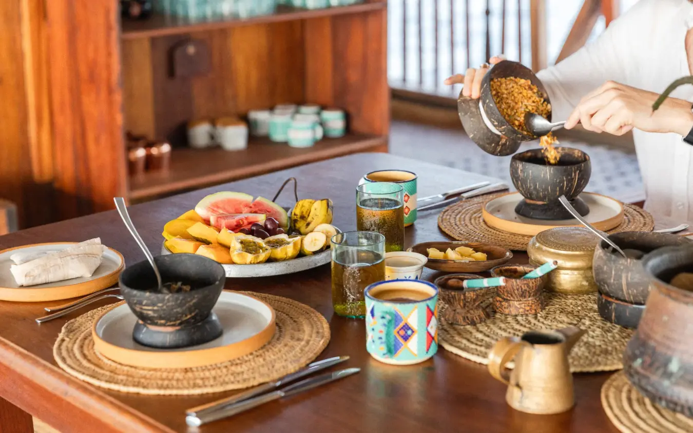 Dining table set with coconut bowls and traditional cuisine service, NaiSabah, Lamu Archipelago, Kenya