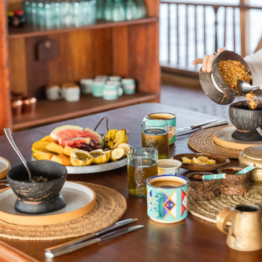 Dining table set with coconut bowls and traditional cuisine service, NaiSabah, Lamu Archipelago, Kenya