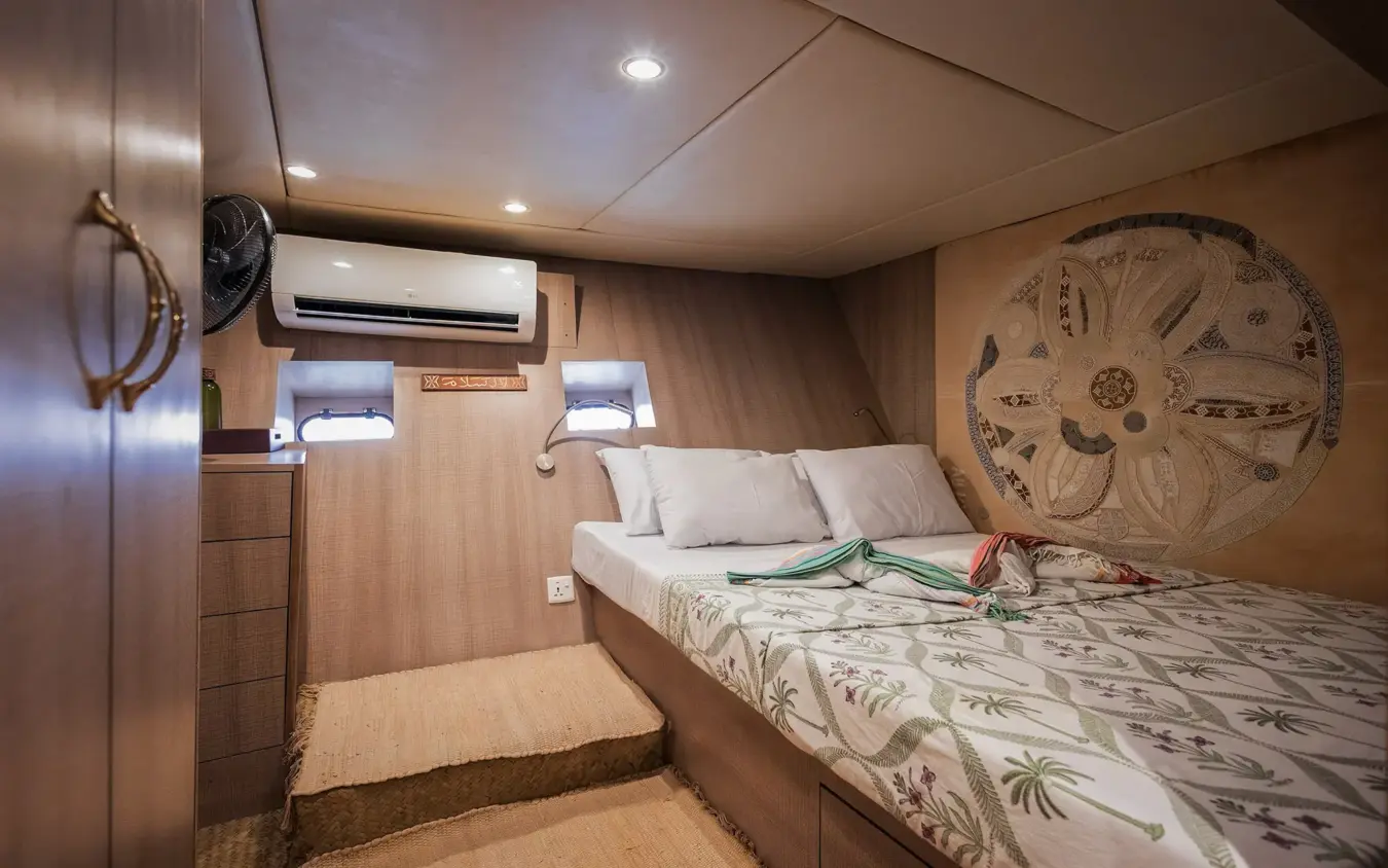 Luxury yacht cabin with queen bed and porthole windows, NaiSabah, Lamu Archipelago, Kenya