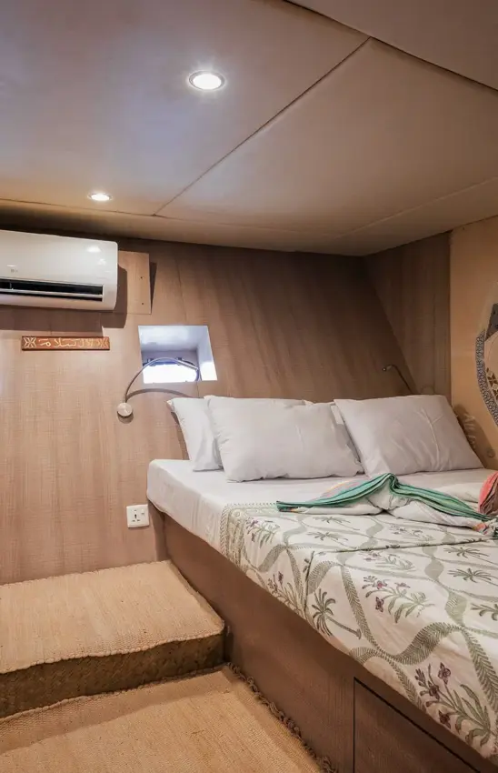 Compact bedroom interior in luxury safari vehicle with recessed lighting, NaiSabah, Lamu Archipelago, Kenya