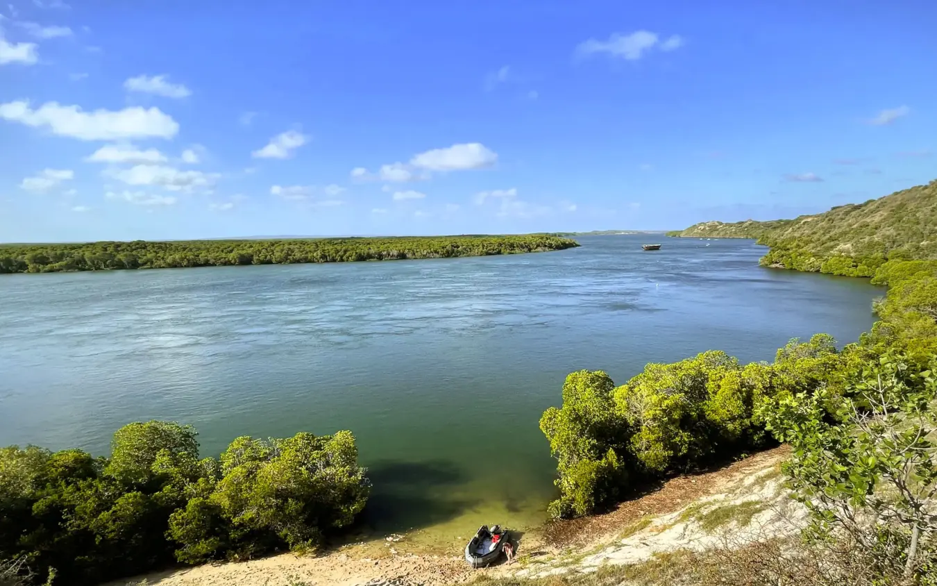 Tourists at riverside viewpoint overlooking waterway with mangrove vegetation, NaiSabah, Lamu Archipelago, Kenya