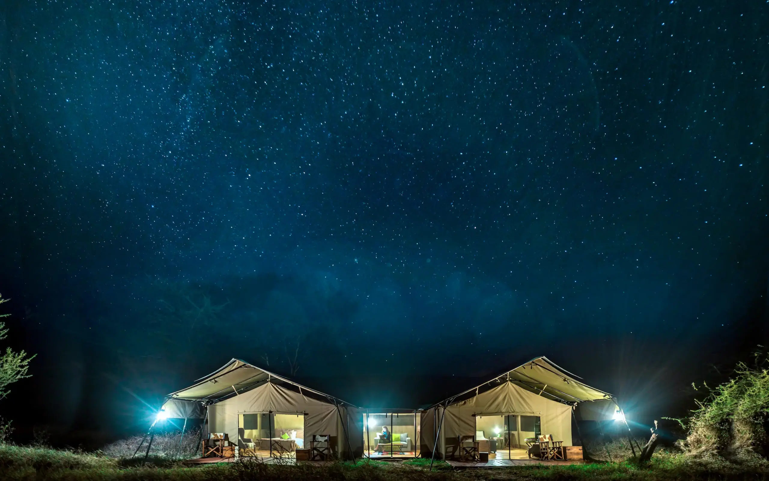 Illuminated safari tents under starry night sky, Ndutu Mobile Tented Camp, Serengeti National Park, Tanzania