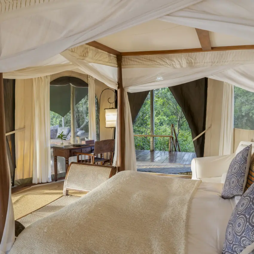 Luxury safari tent bedroom with canopy bed and woodland views, Ngare Serian, Maasai Mara, Kenya
