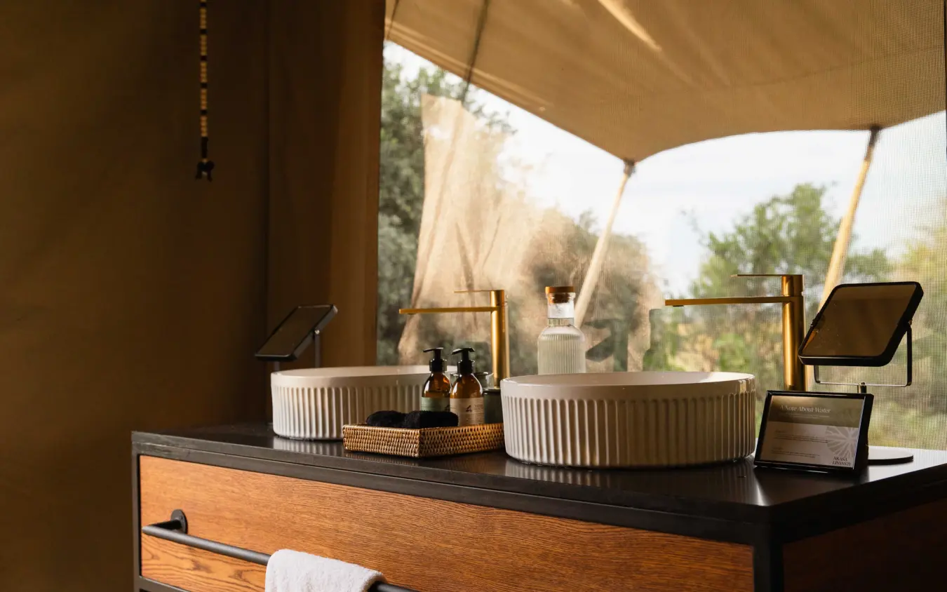Luxury safari tent bathroom with dual sinks overlooking savanna landscape, Nkasa Linyanti, Zambezi Region, Namibia