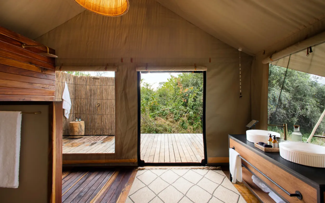 Safari tent bathroom with wooden vanity and outdoor deck views, Nkasa Linyanti, Zambezi Region, Namibia