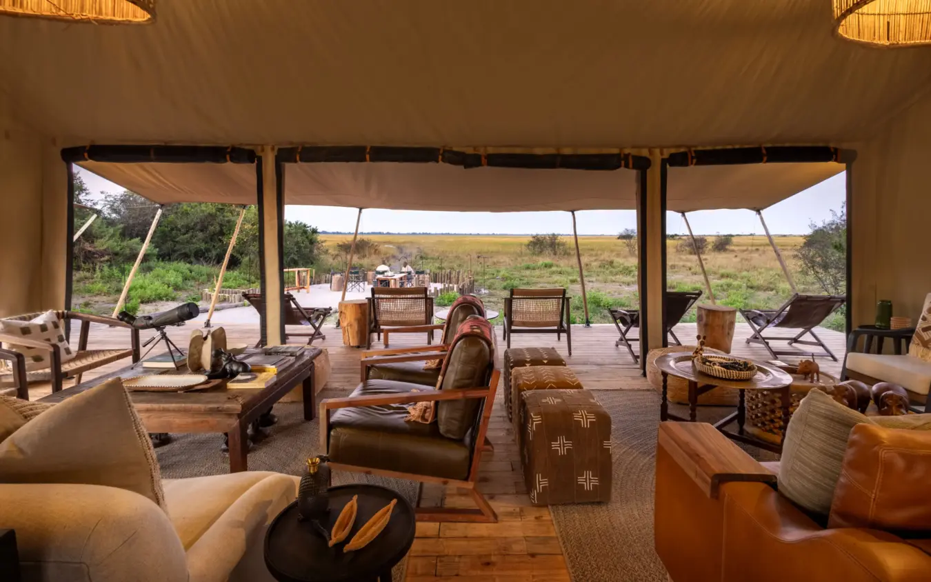 Luxury lounge tent with leather seating overlooking vast savanna landscape, Nkasa Linyanti, Zambezi Region, Namibia