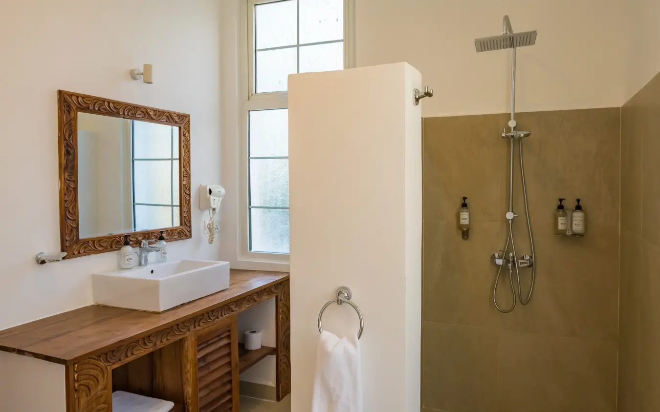 Luxury bathroom with wooden vanity, framed mirror and walk-in rainfall shower, Ocean Boutique Hotel, Zanzibar & Pemba, Tanzania