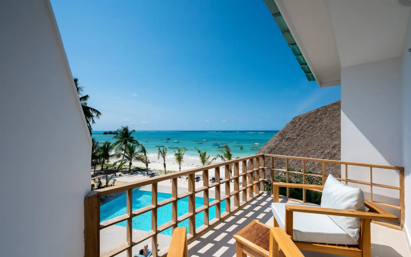 Beachfront balcony with wooden furniture overlooking turquoise ocean and palms, Ocean Boutique Hotel, Zanzibar & Pemba, Tanzania