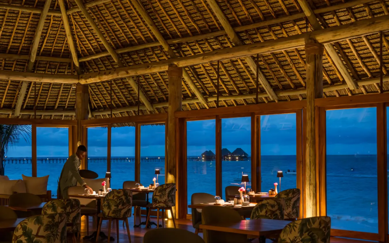 Overwater restaurant with thatched roof at twilight, ocean views, Ocean Boutique Hotel, Zanzibar & Pemba, Tanzania